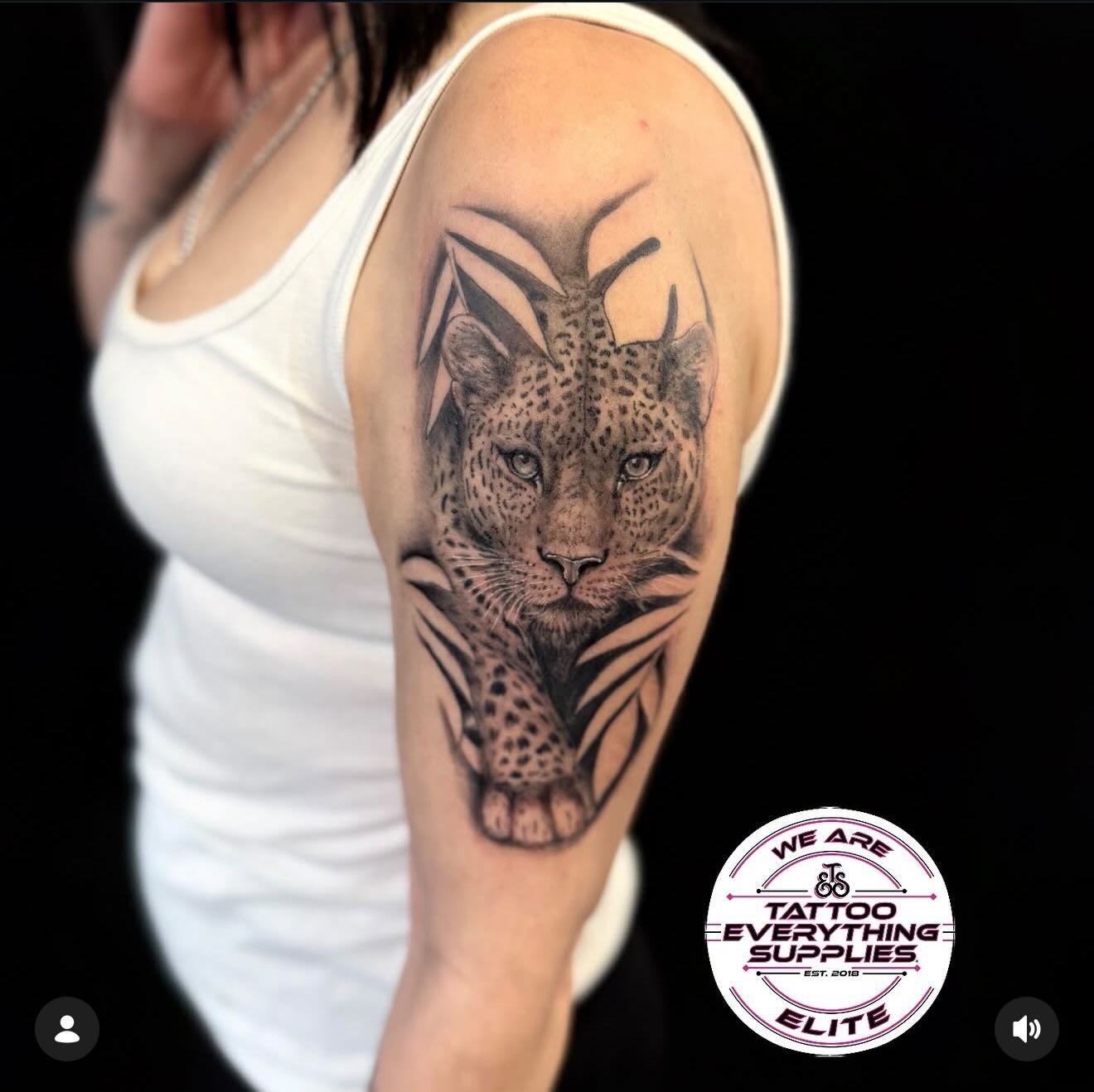 Black and grey leopard tattoo on upper arm