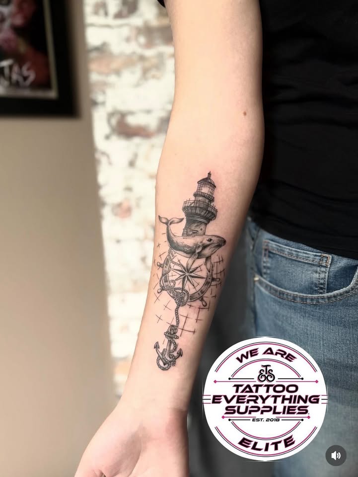 Lighthouse, whale and compass tattoo on forearm