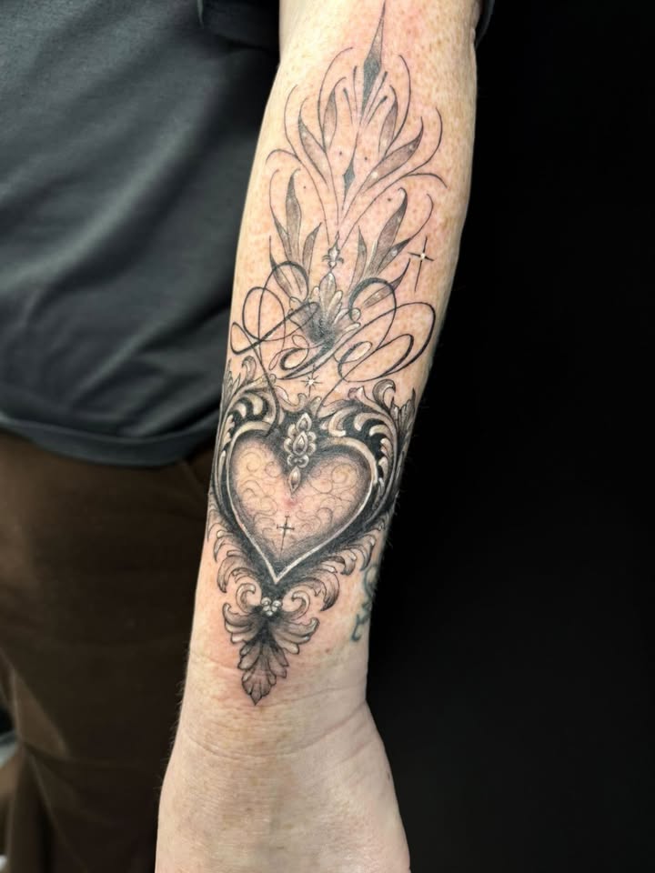 Ornate sacred heart tattoo on forearm